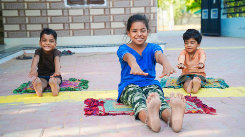 Asian girl doing gymnastic exercises or exercising in fitness class with little siblings.