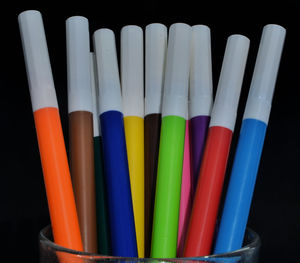 Close-up of colored pencils on table against black background