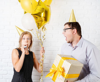 Portrait of a young couple holding balloons