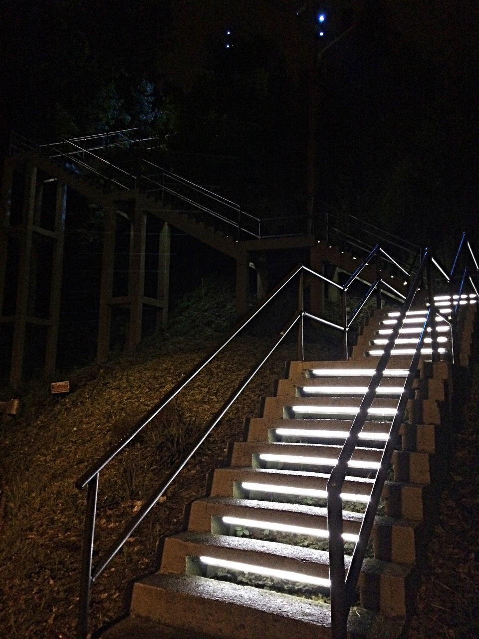 night, railing, steps, built structure, illuminated, steps and staircases, architecture, staircase, the way forward, empty, railroad track, absence, building exterior, metal, diminishing perspective, no people, outdoors, high angle view, rail transportation, lighting equipment
