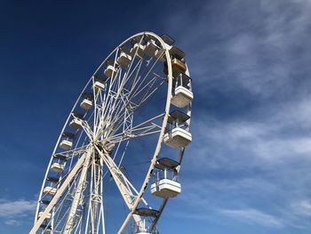 Low angle view of ferris wheel against blue sky