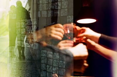 Double exposure of people toasting drinks and couple on sidewalk