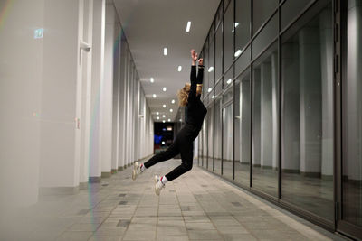 Woman jumping in illuminated building