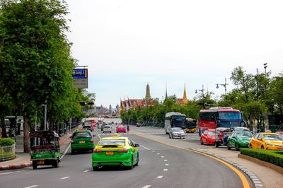 Cars on street in city against sky