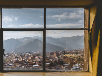 Cityscape against mountains seen through window