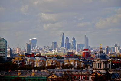 Buildings in city against cloudy sky