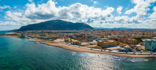 High angle view of townscape by sea against sky