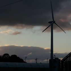 Low angle view of windmill against cloudy sky