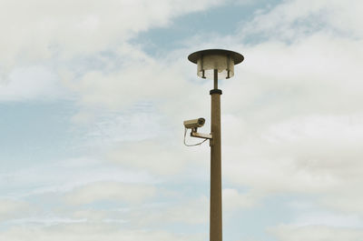 Low angle view of security camera on pole against sky