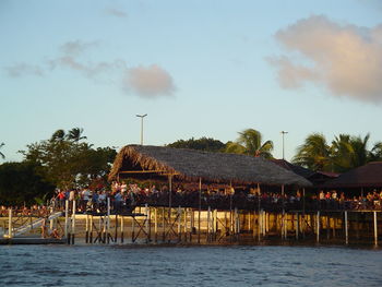 Gazebo by palm trees against sky