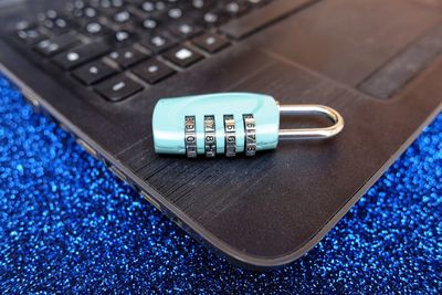 Close-up of lock with laptop on table