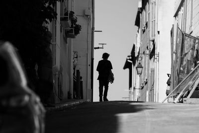 Rear view of man walking on road