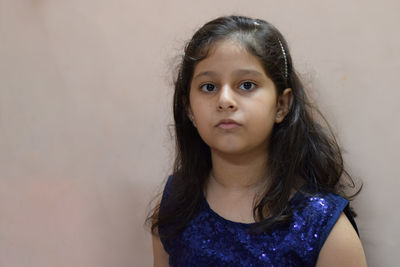 Portrait of cute girl against wall