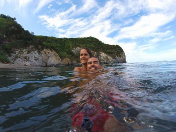 Rear view of young woman swimming in sea