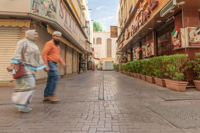 People walking on street amidst buildings