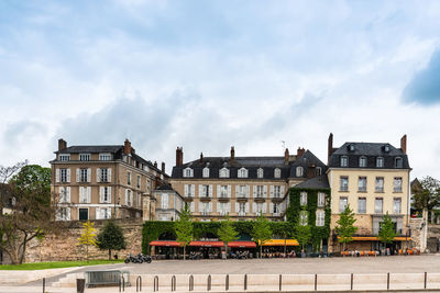 Low angle view of buildings against cloudy sky