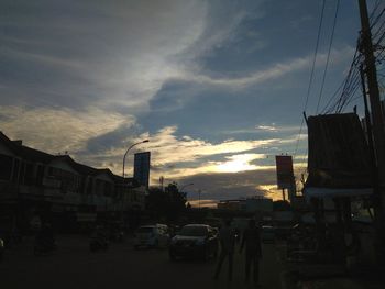 Cars on road against sky during sunset