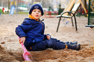 Boy sitting on swing in playground