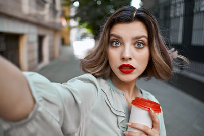 Portrait of beautiful woman holding red outdoors