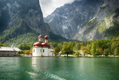 View of temple by building and mountains