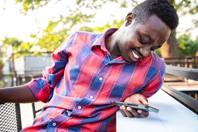 Young man using mobile phone outdoors