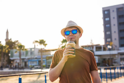 Portrait of man wearing sunglasses standing against sky