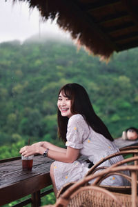 Portrait of a smiling young woman sitting outdoors