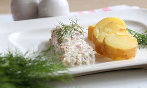 Roasted salmon with creme fraiche in plate on table