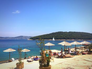 Scenic view of beach against clear blue sky