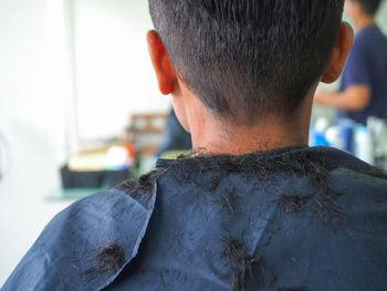 Rear view of man in apron at barber shop