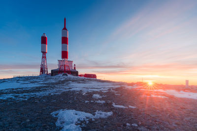 Station with radio and television signal repeater antennas with curious rocket shape located on snowy mountain on winter day in spain