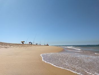 Scenic view of beach against clear blue sky