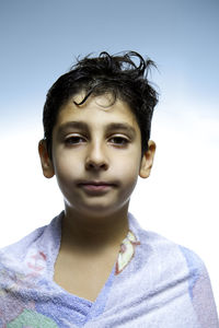 Portrait of boy wrapped in towel against clear sky