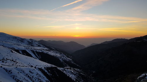 Scenic view of snowcapped mountains against sky during sunset