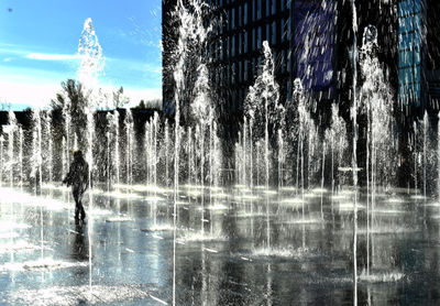 Fountain in city against sky