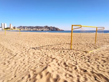 Scenic view of beach against clear blue sky