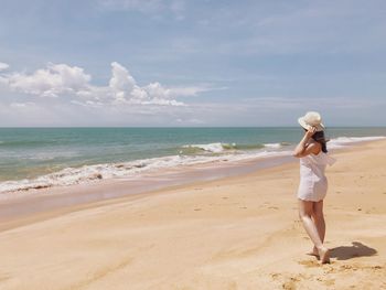 Full length of woman on beach against sky