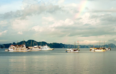 Sailboats moored in sea against sky