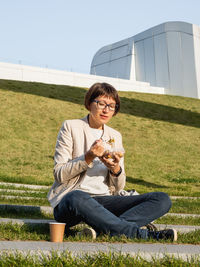 Woman on park bench with lunch box, coffee.healthy bowl with vegetables.urban lifestyle. 