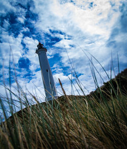 Low angle view of lighthouse on field against sky