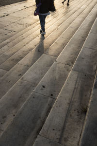 Low section of woman walking on footpath