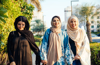 Portrait of smiling young women standing outdoors
