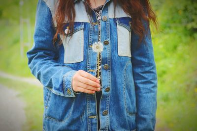 Mid section of a girl holding dandelion flower