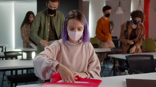 Side view of female friends working at office