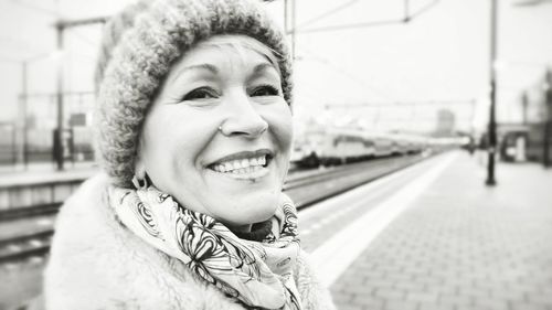 Close-up portrait of woman standing at railroad station