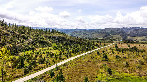 Scenic view of road by mountains against sky