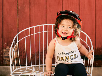 Portrait of a young girl toddler in the backyard wearing a biking helmet