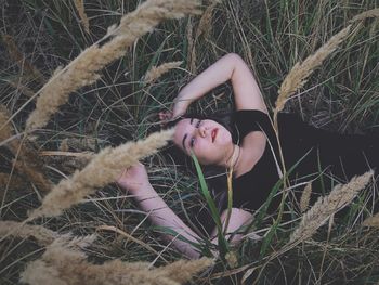 High angle portrait of woman lying down on land