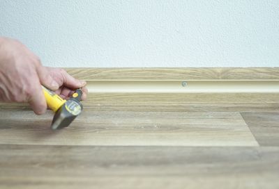 Close-up of person holding hands against wall