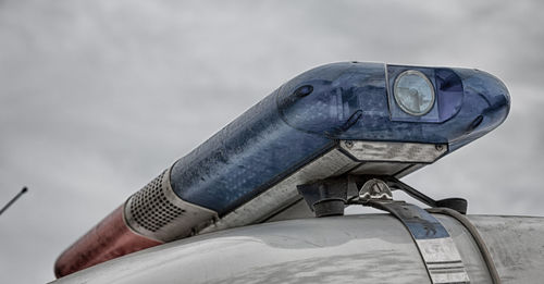 Low angle view of lighting equipment on ambulance car against sky